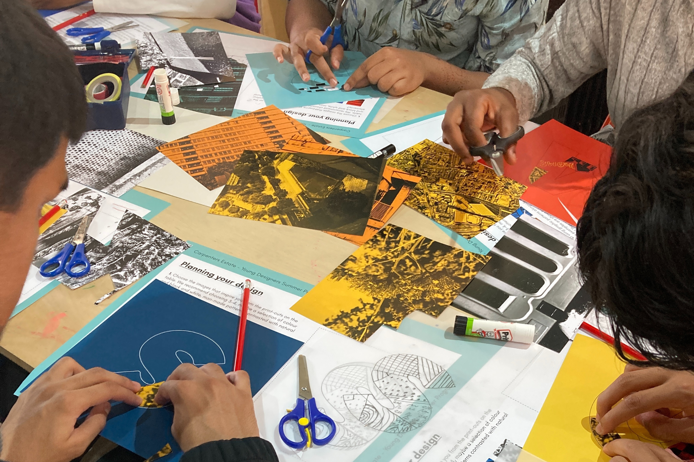 Young people gathered around a table, making paper clipping collages