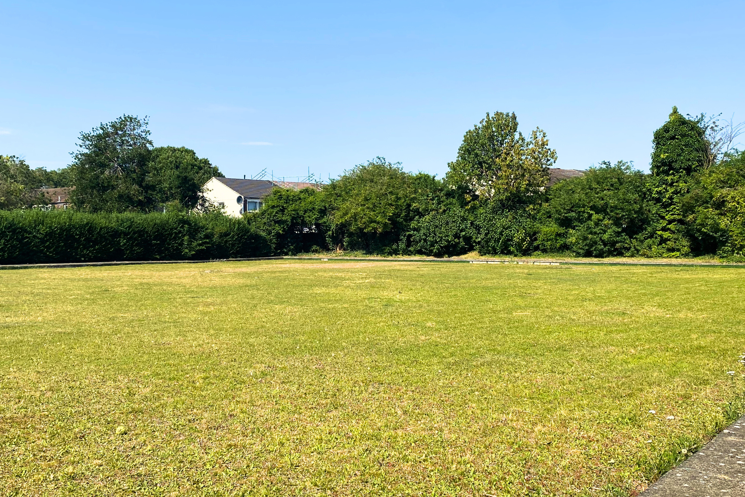 A large, empty green space that used to be the old bowling green